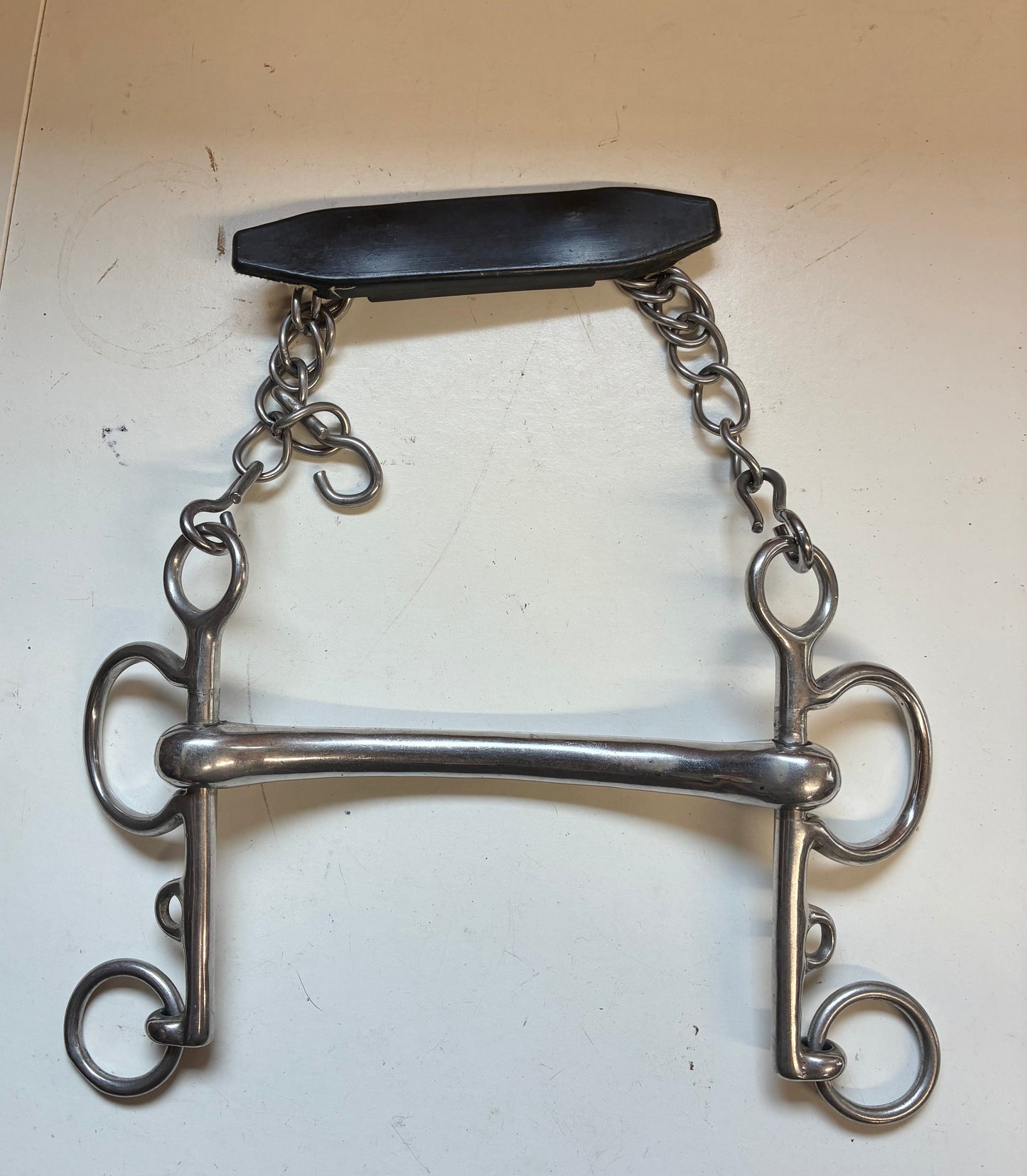 rugby Pelham bit with a solid curved mullen mouth and an attached curb chain with a rubber guard
size 5.5”