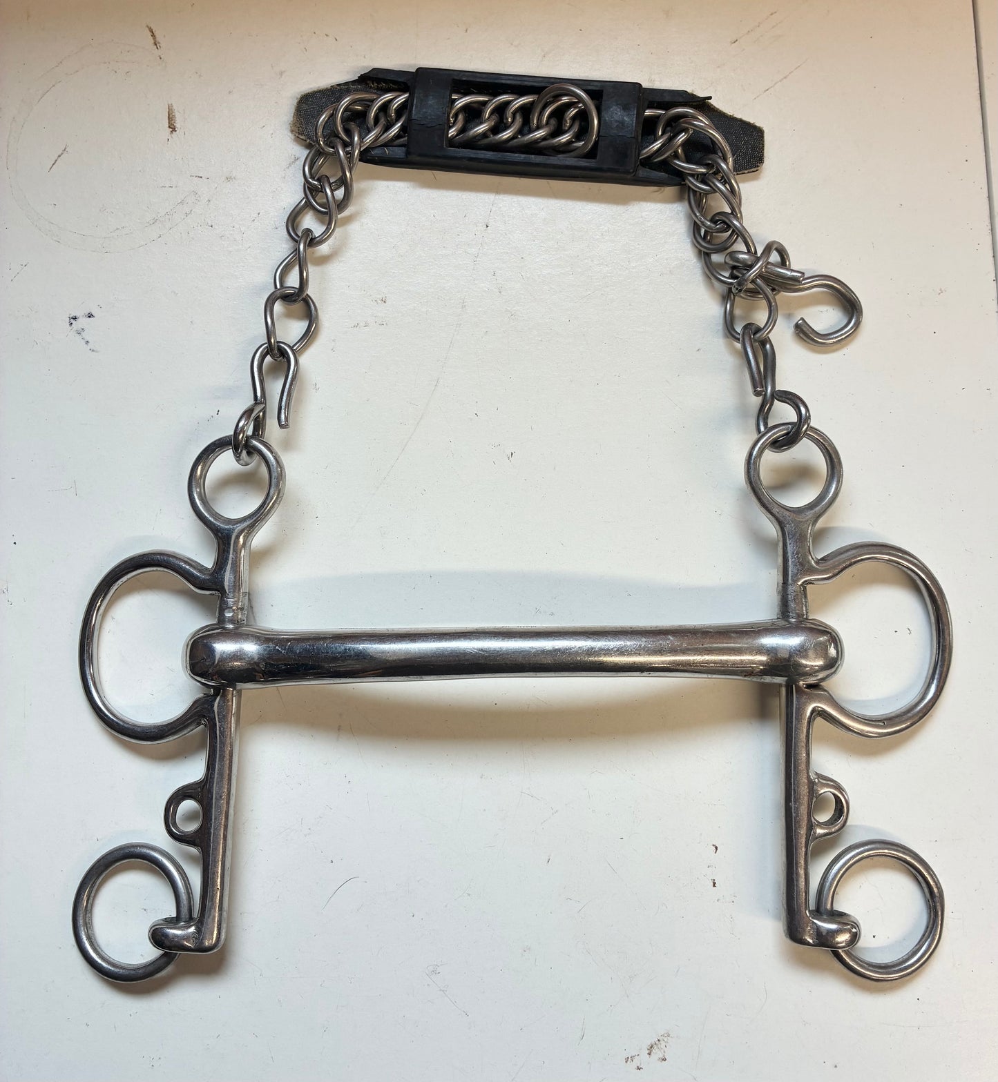 rugby Pelham bit with a solid curved mullen mouth and an attached curb chain with a rubber guard

size 5.5”